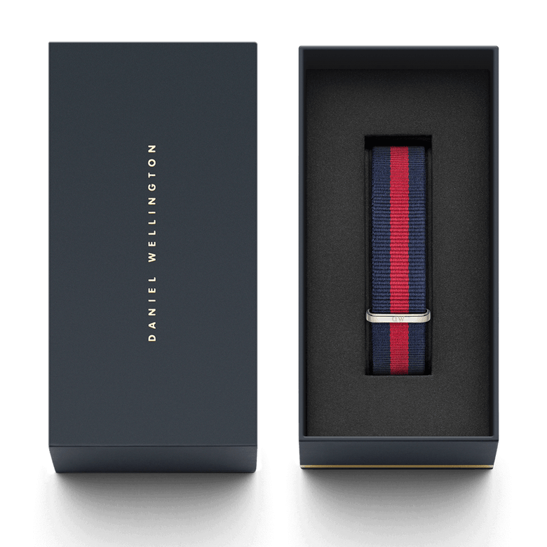 Oxford Strap Silver NATO style watch strap in navy blue and red stripes, presented in a premium Daniel Wellington gift box with a polished silver buckle.