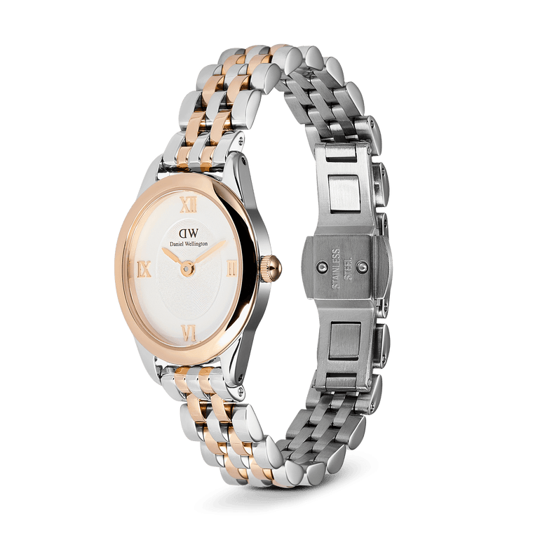 Daniel Wellington Ophelia Mini Two Tone Rose Gold watch with a slim oval case, white dial, rose gold Roman numerals, and a polished rose gold and silver five-link stainless steel bracelet with an open butterfly clasp.