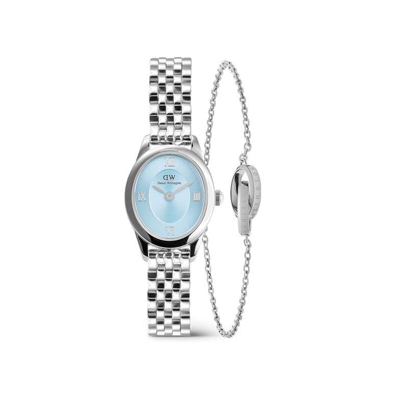 A petite Daniel Wellington watch with a polished silver link strap and an ice blue oval dial, paired with a delicate silver Elan Unity Bracelet featuring a fine chain and signature ring detail.