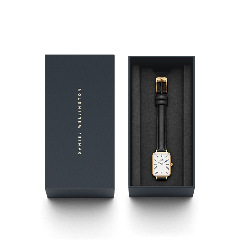 Quadro Roman Numerals Sheffield Gold ladies watch with a rectangular gold case, white dial, Roman numerals, and black leather strap, elegantly presented in a branded Daniel Wellington gift box.