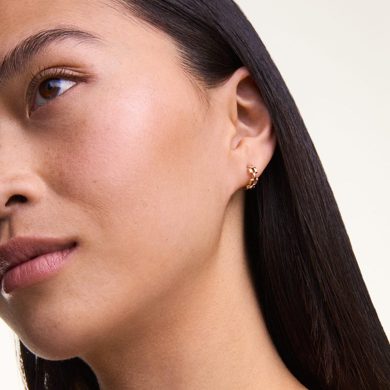 A woman wears a single 3-Link Earrings Rose Gold hoop, showcasing its geometric open link design and warm rose gold finish for a modern, understated look.