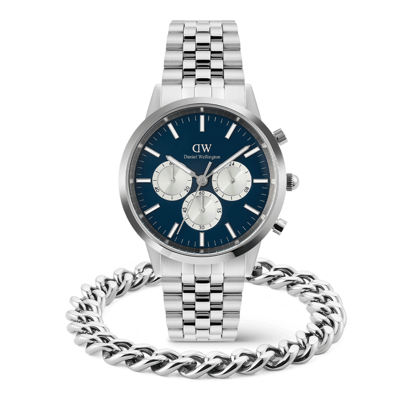 A silver Daniel Wellington chronograph men's watch with a blue dial and silver subdials is paired with a polished Ellipse Cuban Chain Bracelet, both featuring a matching stainless steel finish for a cohesive and modern look.