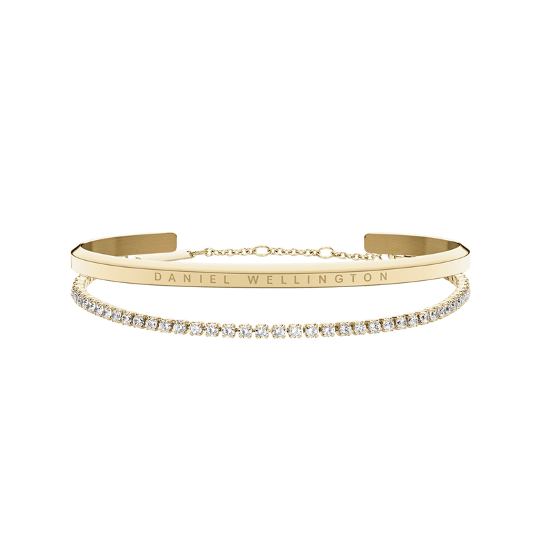 Classic & Tennis Bracelet Gold set featuring a polished gold cuff with engraved branding and a delicate tennis bracelet adorned with clear sparkling stones, displayed together against a plain background.