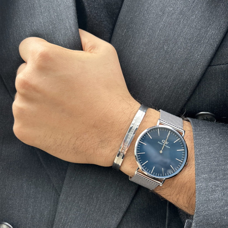 Elan Bracelet Silver worn alongside a silver mesh watch, styled with a formal grey suit, highlighting the bracelet’s slim profile and polished finish for a sophisticated business look.
