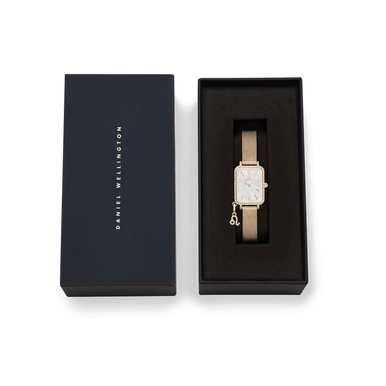 Quadro Crystal Zodiac Evergold gold watch for women with a crystal-framed bezel, mother of pearl dial, and zodiac charm, presented in a branded Daniel Wellington gift box.