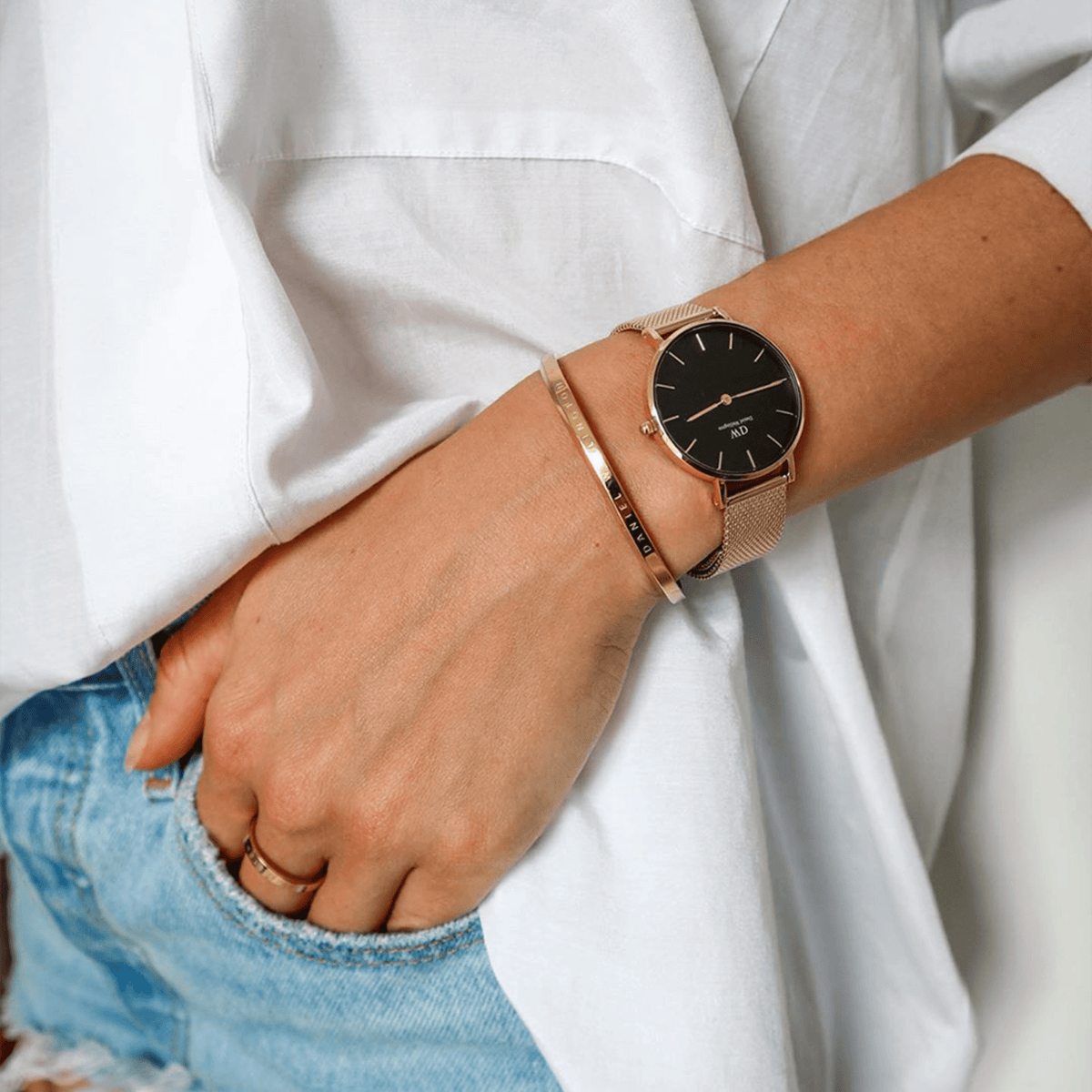 Petite Evergold Black gold mesh strap watch worn on a woman's wrist, styled with a gold bangle and casual denim and white shirt, highlighting its elegant and versatile design for everyday wear.
