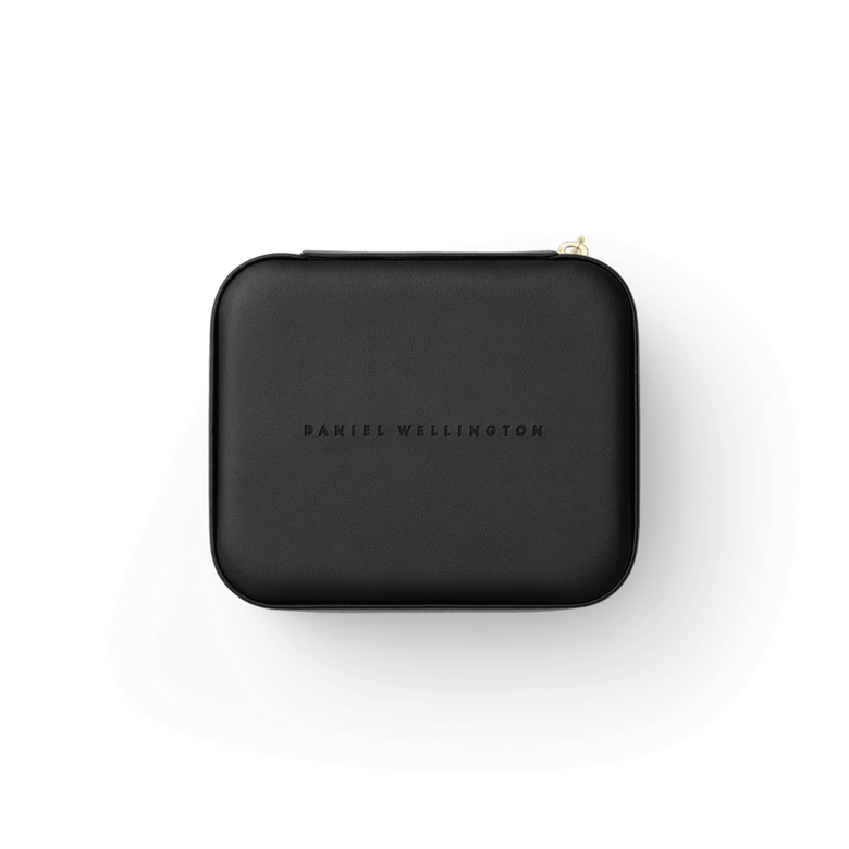 Travel Jewellery Box Black by Daniel Wellington with a smooth black exterior, embossed branding, and gold zip, designed for stylish and secure accessory storage during travel.