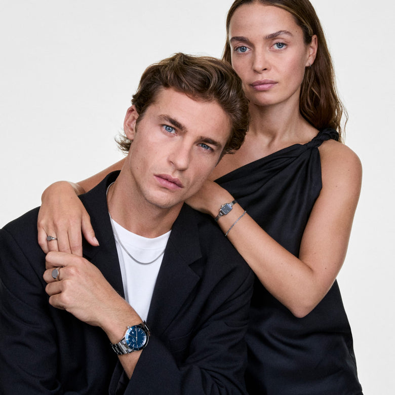 A man wearing the Tide Mesh Necklace Silver 1.8 styled with a black blazer and white t-shirt, showing the necklace’s slim mesh chain and polished silver finish as it sits neatly at the collarbone.