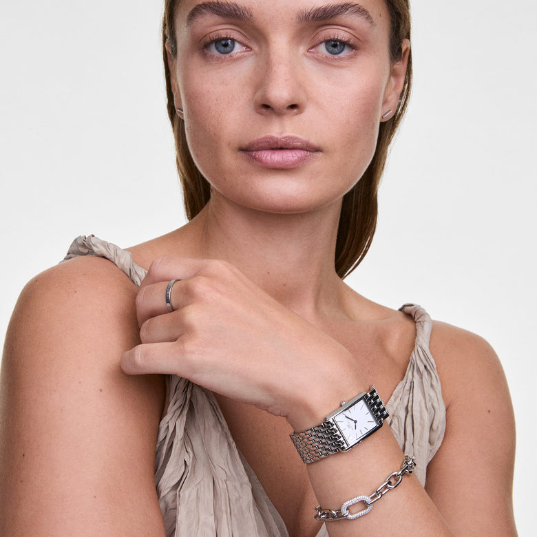 A woman wearing the Classic Ring in silver on her finger, styled with a silver watch and bracelet for a coordinated, elegant look.