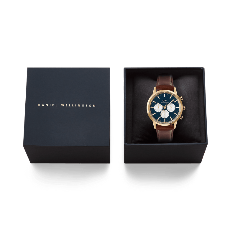Iconic Chronograph St Mawes Arctic Panda Gold watch with a gold case, blue panda dial, and brown leather strap, elegantly presented in a black Daniel Wellington gift box.