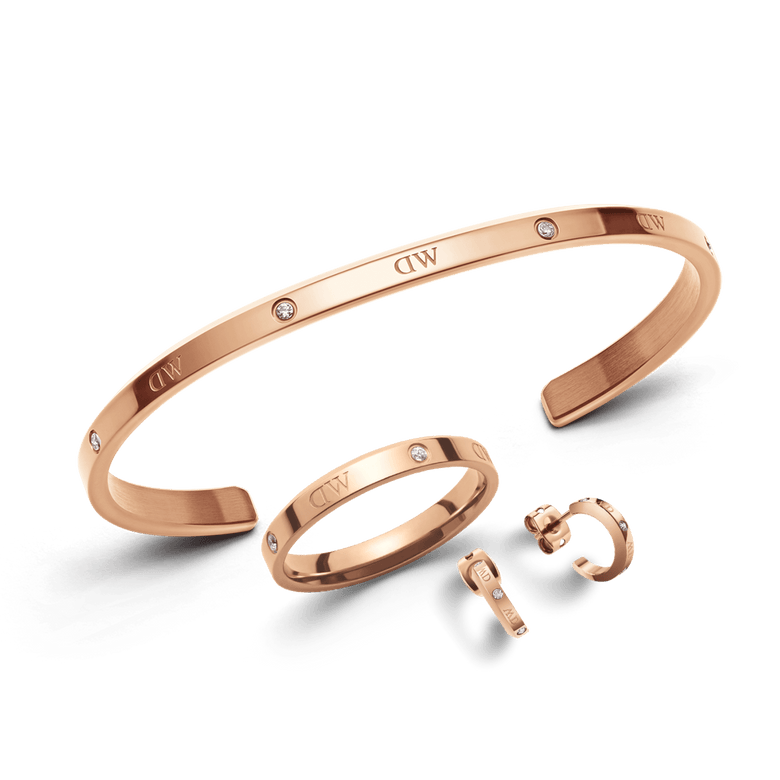 Rose gold Lumine Jewelry Set featuring a minimalist open cuff bracelet, smooth band ring, and dainty earrings, each accented with delicate diamanté details and polished for a refined, elegant finish.