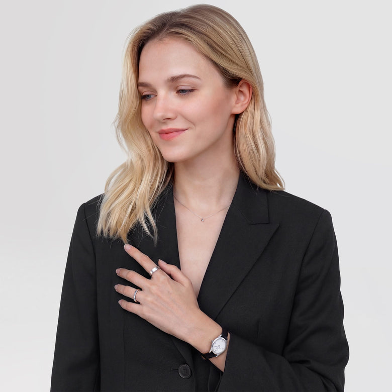 A woman wearing the Ophelia Mini Black Lizard White Guilloché Silver watch styled with a tailored black blazer, showing the petite oval dial and textured black leather strap paired for a modern, elegant look.