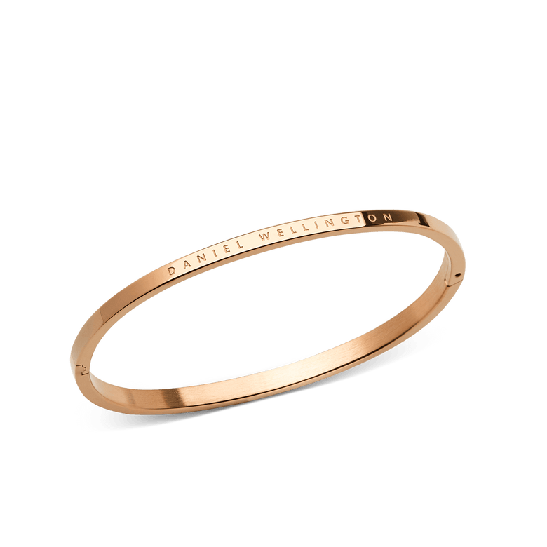 Classic Bangle Rose Gold featuring a slim, polished rose gold finish with the DANIEL WELLINGTON logo engraved on the outer edge, highlighting its minimalist and elegant design.