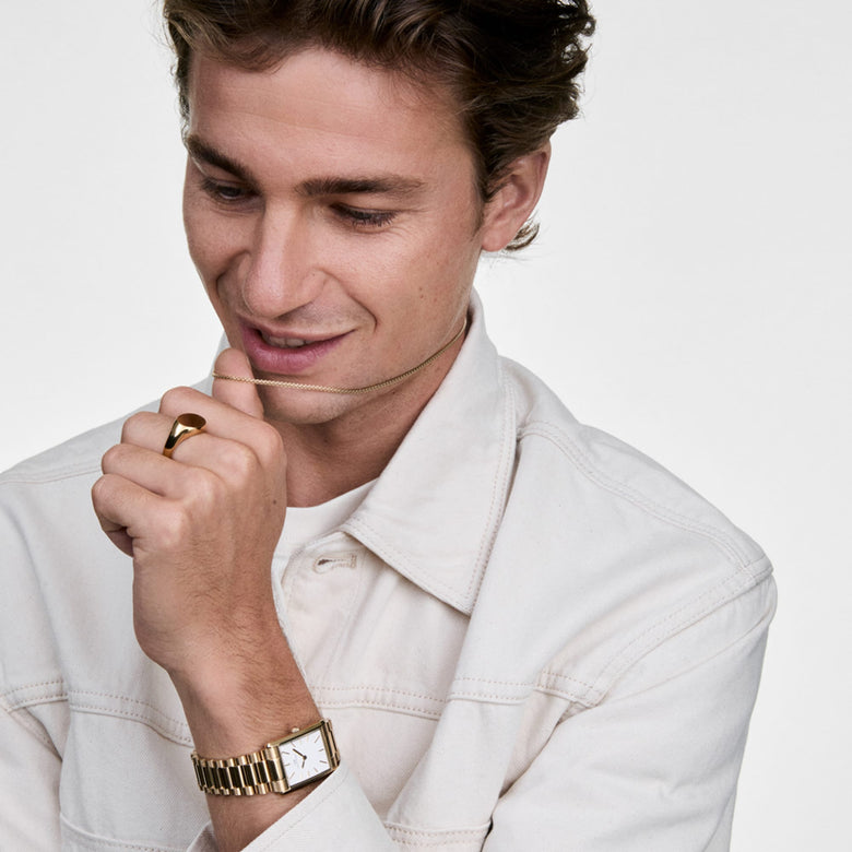A man wearing the Tide Mesh Necklace Gold 2.8 styled with a light shirt, paired with a gold watch and ring for a modern, coordinated look.