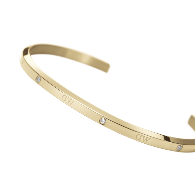 Classic Lumine Bracelet G shown in a curved angle, highlighting its slim gold cuff, polished finish, and six sparkling crystals for a refined, minimalist look.