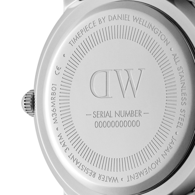 Close-up of the Daniel Wellington Iconic Black NATO Black Dial watch case back, showing engraved branding, serial number, and details about stainless steel construction, Japanese movement, and water resistance.