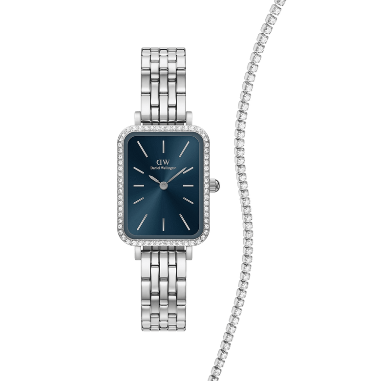 Rectangular Daniel Wellington Quadro Bezel Arctic watch with a polished silver link strap, deep blue dial and crystal-set bezel, paired with a classic silver tennis bracelet featuring a row of sparkling stones.