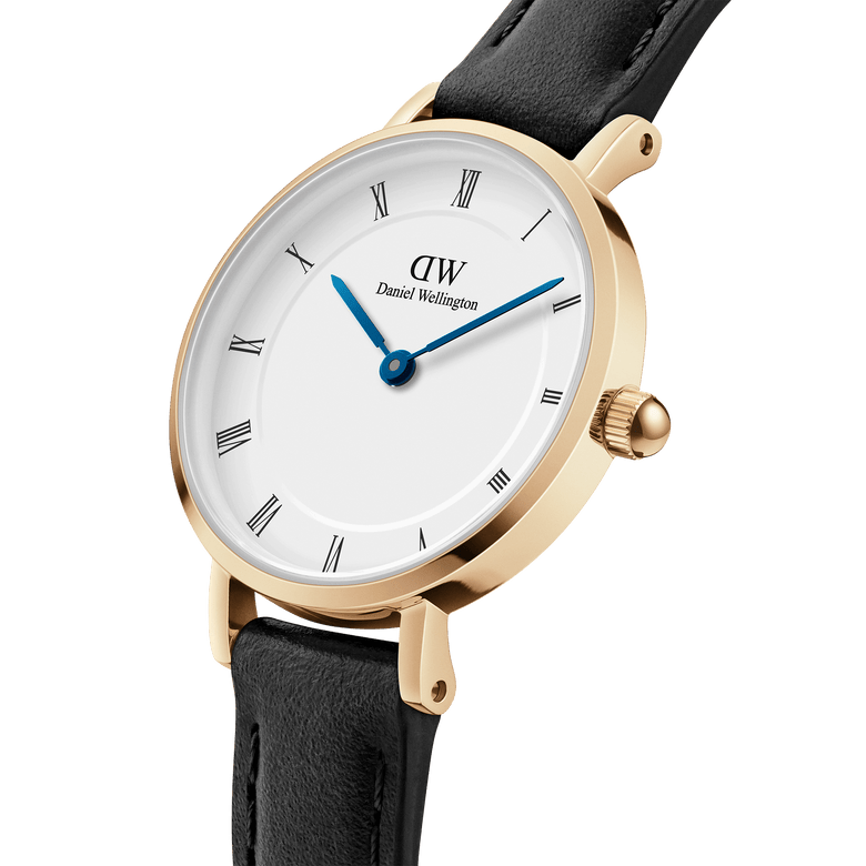 Close-up of the Petite Roman Numerals Sheffield Gold watch showing its gold-plated case, crisp white dial with Roman numerals, blue steel hands, and a slim black leather strap.