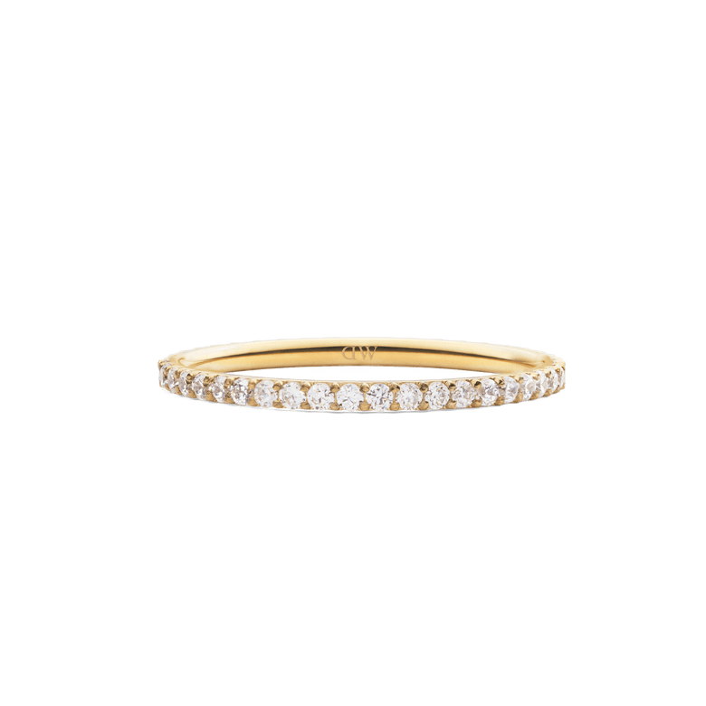 The Mirelle Eternity Ring Gold 1.4 mm features a slim gold band set with a continuous row of sparkling white cubic zirconia crystals, offering a refined and elegant look.