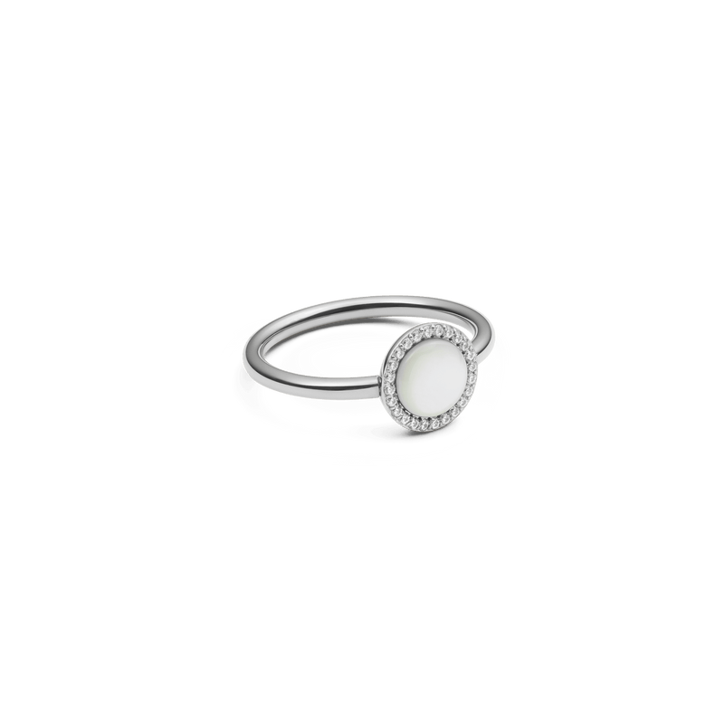 The Audrey Ring Mother of Pearl Silver features a round mother of pearl centrepiece framed by a halo of white cubic zirconia on a slim silver band, highlighting its elegant and minimalist design.