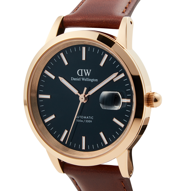 Close-up of the Iconic St Mawes Automatic Rose Gold watch, showcasing its blue enamel dial, rose gold-plated stainless steel case, and brown Italian leather strap with luminous markers and date window.