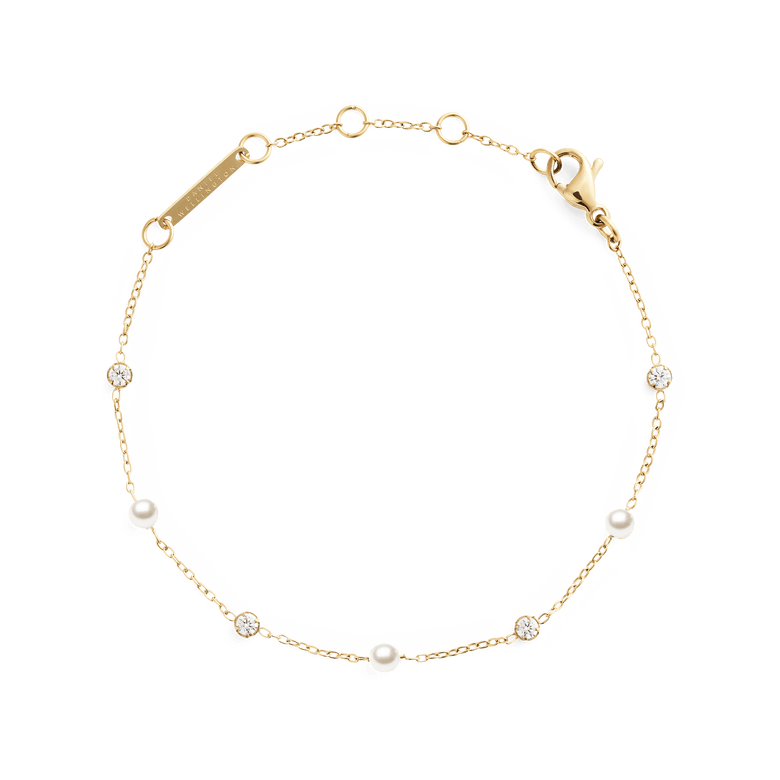 Slim gold chain bracelet featuring alternating white Swarovski glass pearls and cubic zirconia stones, with an adjustable clasp for a comfortable fit.