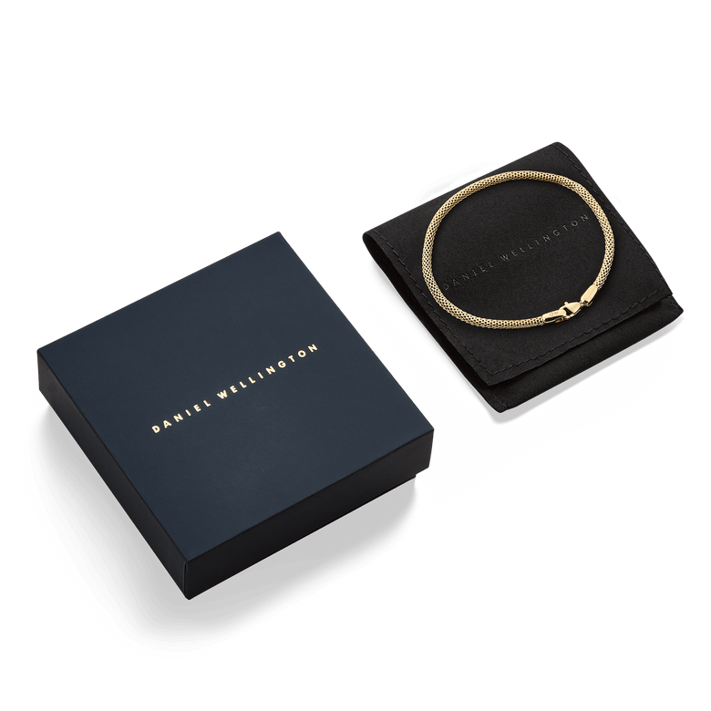 Tide Mesh Bracelet Evergold 2.8 displayed on a black pouch next to elegant Daniel Wellington packaging, highlighting its gold mesh design and suitability as a gift.