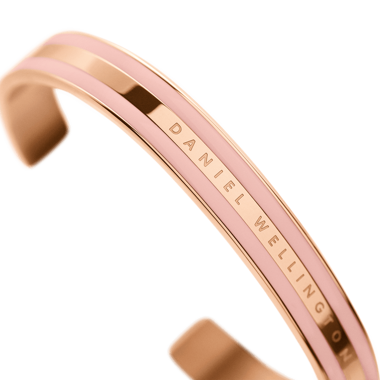 Close-up of the Emalie Bracelet Dusty Rose Rose Gold showing its smooth pink enamel and rose gold finish, with Daniel Wellington branding engraved on the cuff.