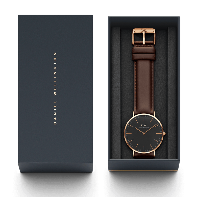 Classic Bristol Black Rose Gold watch with a black dial, rose gold case, and dark brown leather strap, presented in a Daniel Wellington branded gift box.