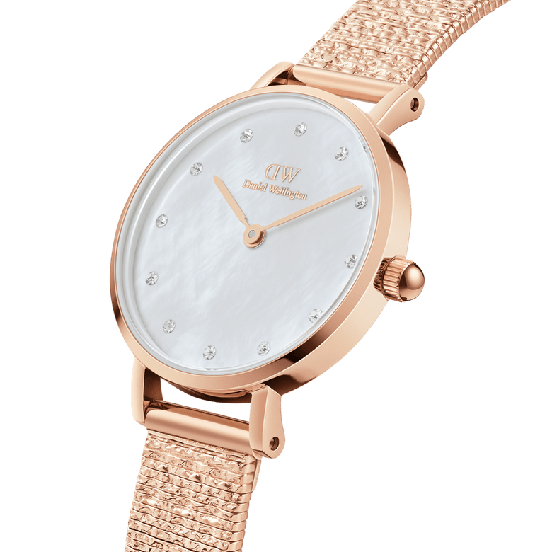 Petite Lumine Pressed Piano White MoP Rose Gold ladies watch featuring a white mother of pearl dial with crystal hour markers and a textured rose gold pressed piano link strap, shown in a close-up angled view.