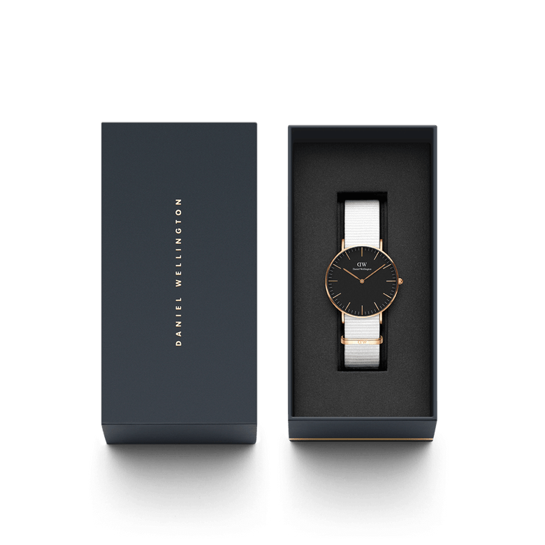 Classic Dover Black Rose Gold watch with a black dial and white NATO strap, elegantly presented in a branded Daniel Wellington gift box, ideal for gifting or personal use.