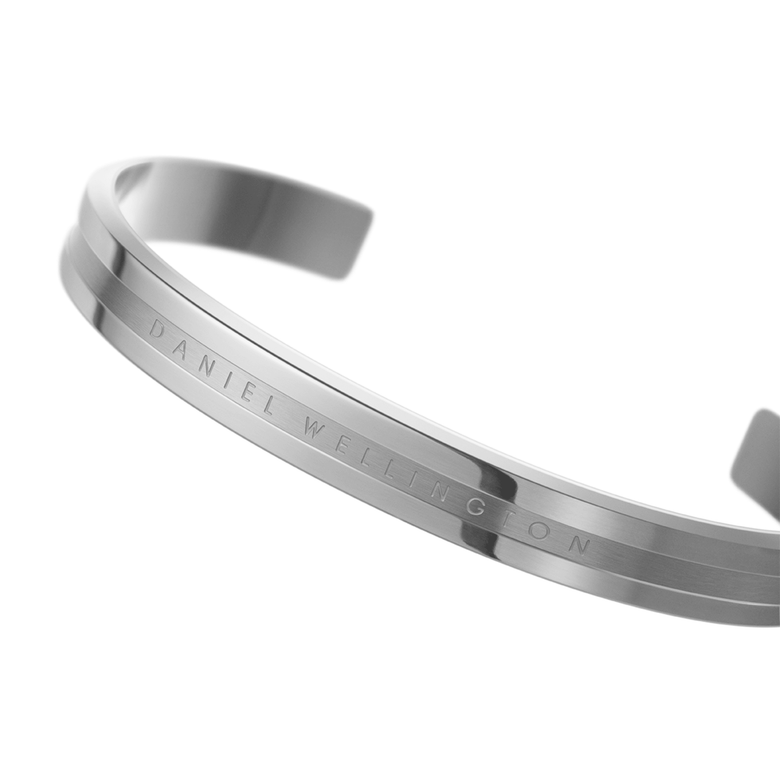 Close-up of the Elan Bracelet Silver showing its polished stainless steel finish, minimalist open cuff shape, and subtle Daniel Wellington logo engraved on the front.
