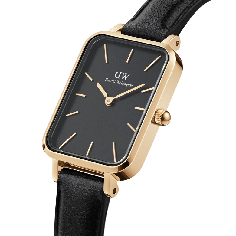 Quadro Pressed Sheffield Black Gold ladies watch with a rectangular gold stainless steel case, minimalist black dial, gold hour markers, and a slim black leather strap, shown in a close-up angled view.