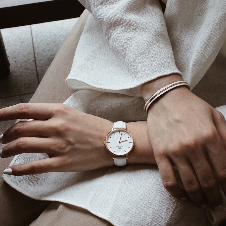 Petite Bondi Rose Gold women's watch with a white leather strap and rose gold case, worn on the wrist with a matching bracelet, styled for a sophisticated everyday look.