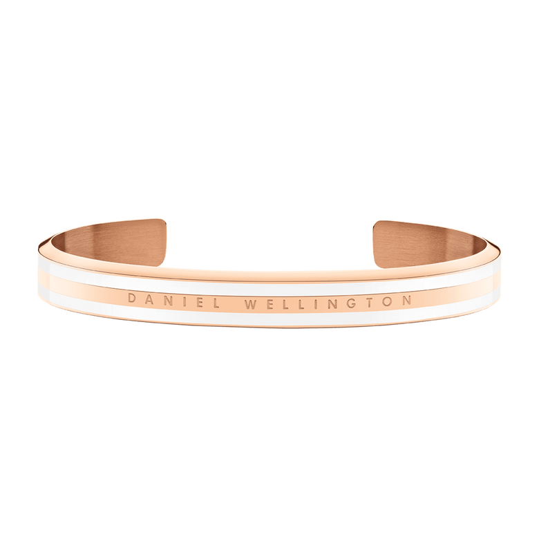 Emalie Slim Bracelet Rose Gold features a slender rose gold cuff with satin white enamel accents and the Daniel Wellington logo engraved on the front, offering a minimalist and elegant jewellery option for everyday wear.
