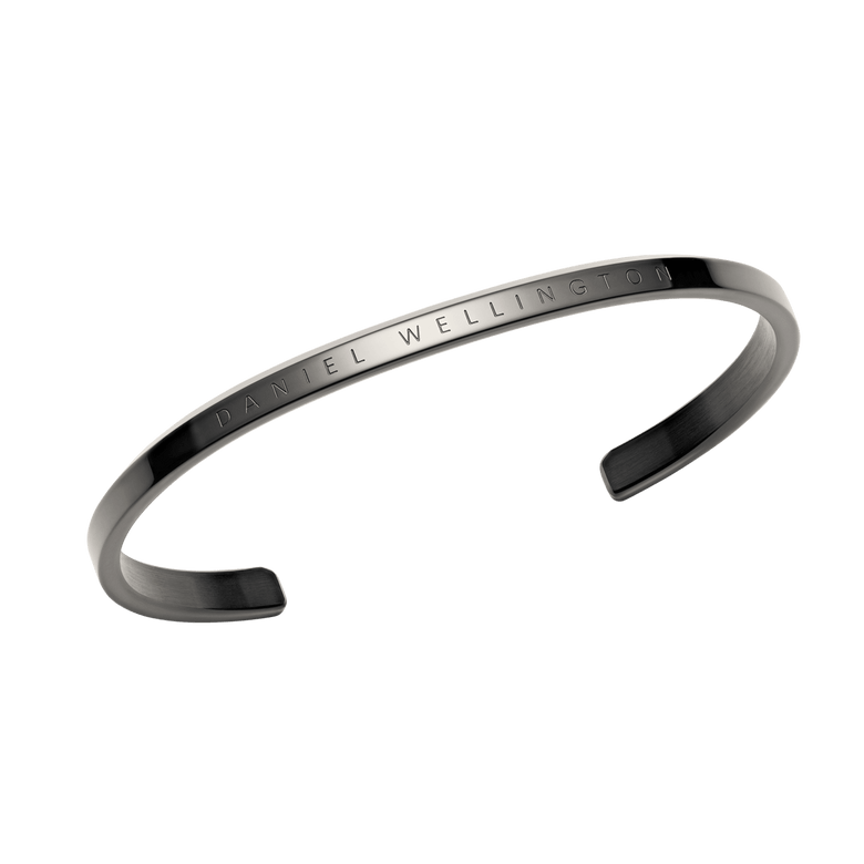 Classic Bracelet Graphite by Daniel Wellington shown from an angled perspective, highlighting its minimalist slim cuff design, graphite finish, and engraved branding for a contemporary jewellery look.
