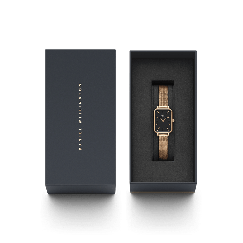 Quadro Pressed Melrose Black Rose Gold watch presented in a sleek Daniel Wellington gift box, featuring a slim rectangular black dial and rose gold mesh bracelet.