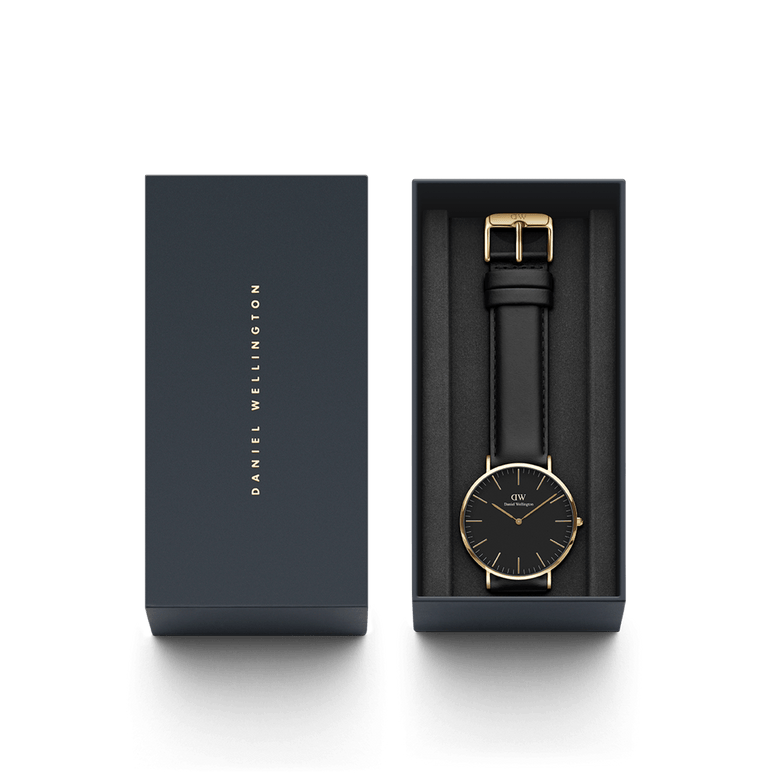 Classic Sheffield Gold watch with a black dial, gold-plated case, and black leather strap, elegantly presented in a Daniel Wellington gift box.