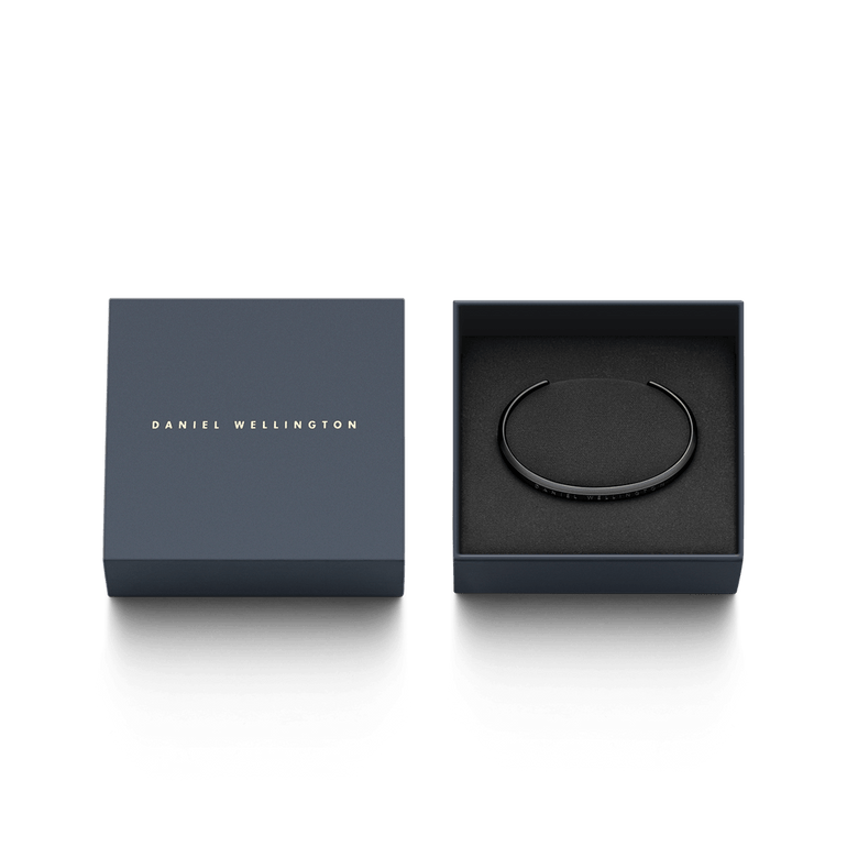 Classic Bracelet in matte black stainless steel displayed in an elegant Daniel Wellington gift box, highlighting its slim cuff design and engraved branding.