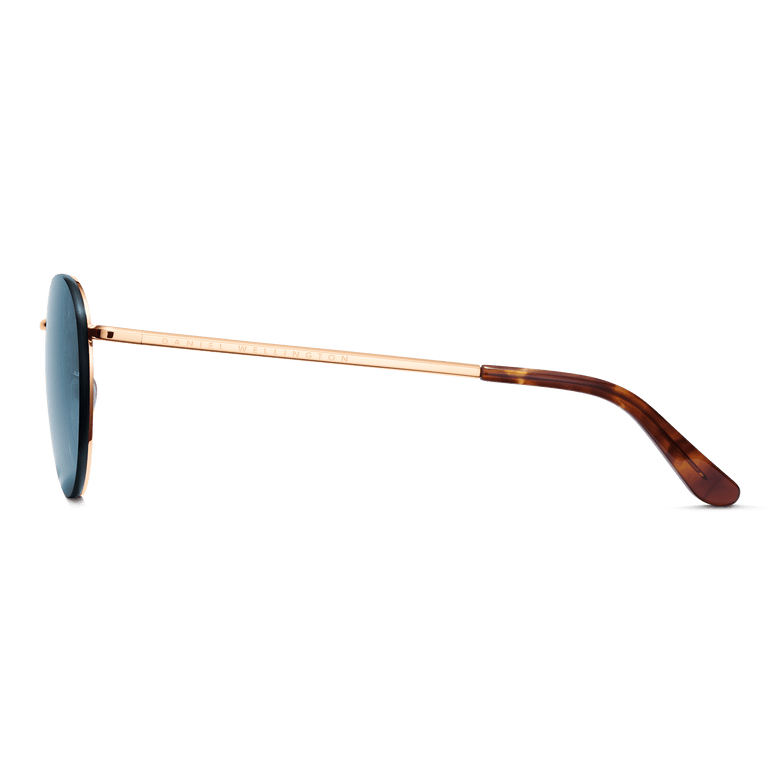 Side view of Arch Steel Blue Rose Gold sunglasses showing the slim rose gold plated stainless steel arm and tortoiseshell acetate temple tip, with blue UV400 lens.