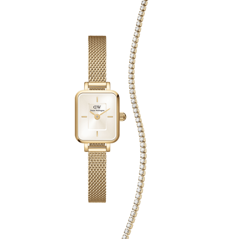Rectangular gold mesh Daniel Wellington Quadro Mini watch with a champagne dial, paired with a gold tennis necklace featuring a row of sparkling crystals.