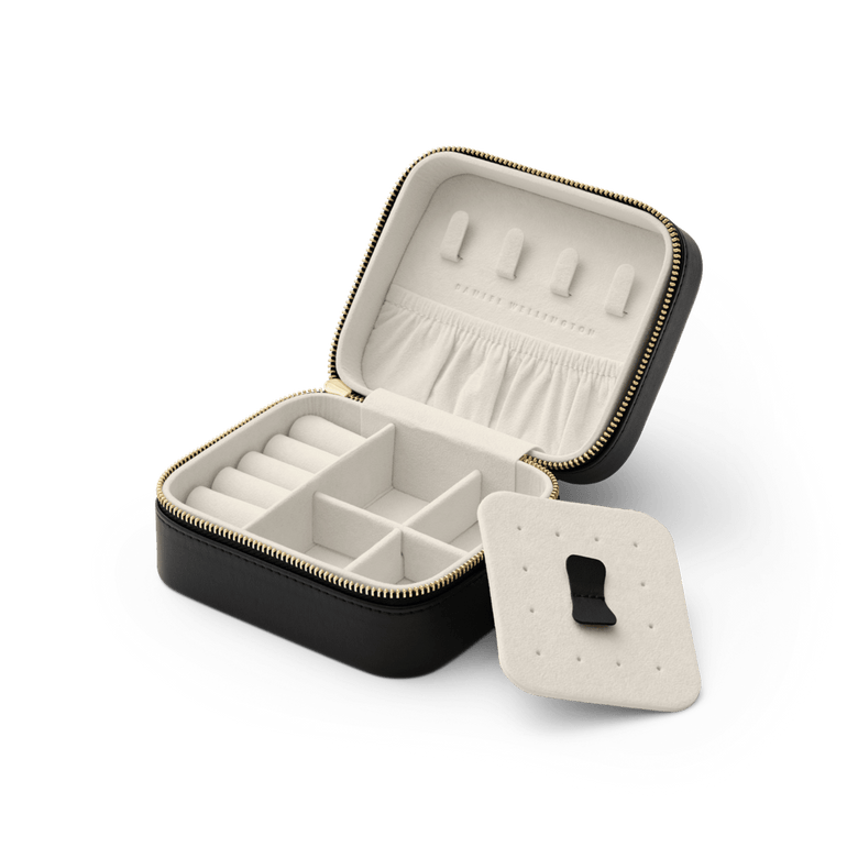 Travel Jewellery Box Black by Daniel Wellington with a gold zip, open to reveal multiple compartments, a pouch pocket, ring holders, and a removable divider for organised storage of accessories.
