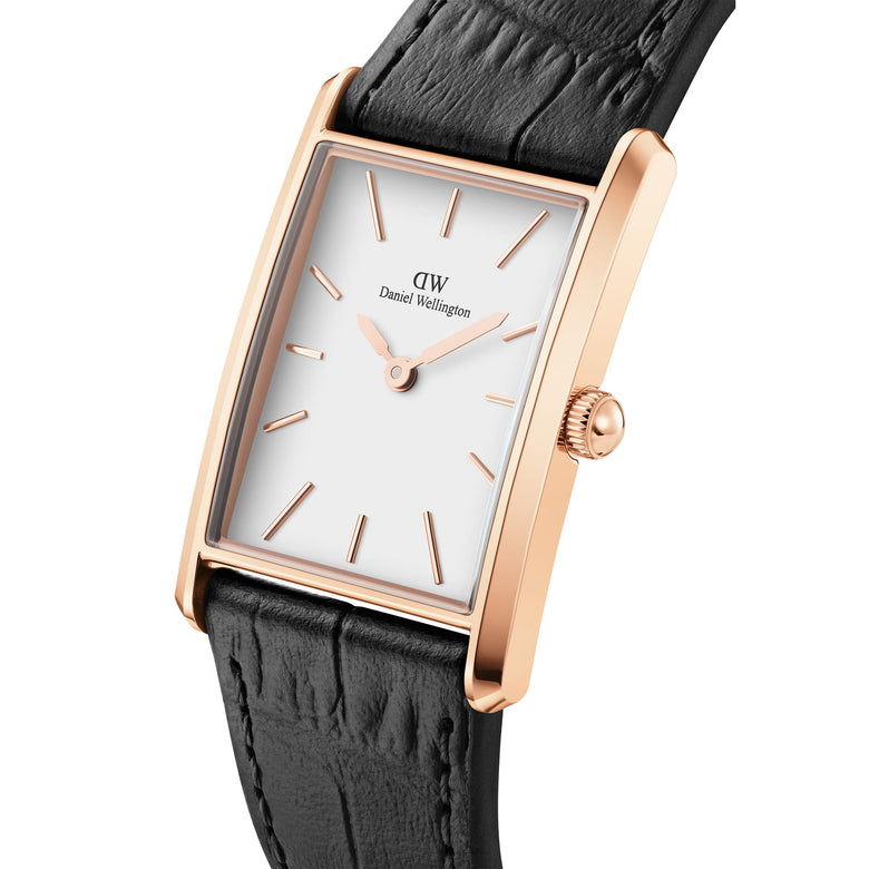 Rectangular rose gold watch with a white dial, slim case and black crocodile-embossed leather strap, highlighting its elegant and modern design.