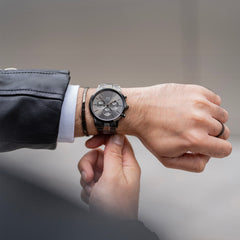 Classic Ring Graphite worn on the finger, styled with a modern graphite-toned watch and leather jacket, showcasing its minimalist design and versatile appeal for everyday wear.