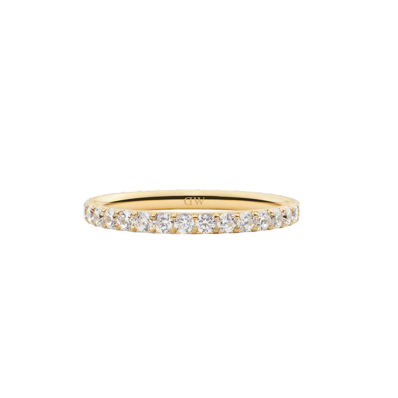 The Mirelle Eternity Ring Gold 2mm features a slim gold band set with a continuous row of sparkling white cubic zirconia crystals, offering a minimalist and elegant look ideal for stacking or wearing alone.