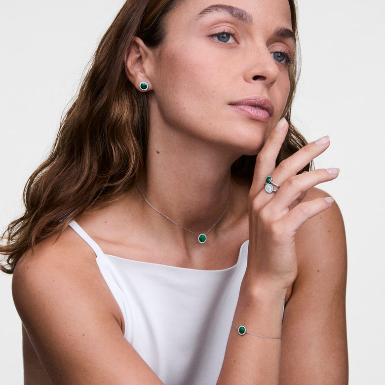 Woman wearing the Audrey Ring Malachite Silver on her finger, styled with matching green malachite jewellery including a necklace, bracelet, and earrings, creating an elegant coordinated look.