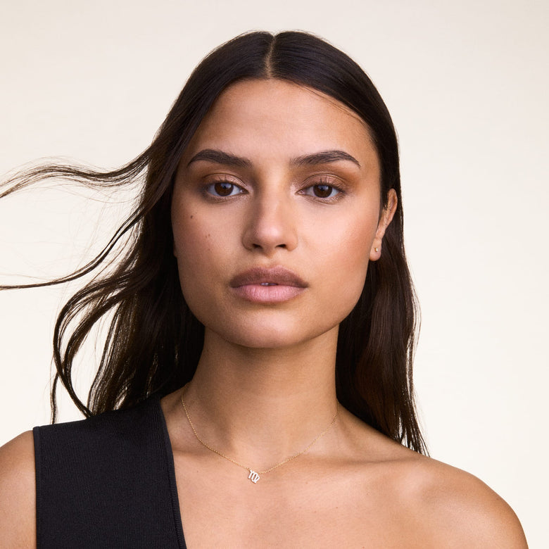 A woman wears the Crystal Zodiac Chain Necklace Rose Gold, featuring a delicate rose gold chain and a sparkling Virgo zodiac pendant set with crystals, styled for a minimalist and elegant everyday look.