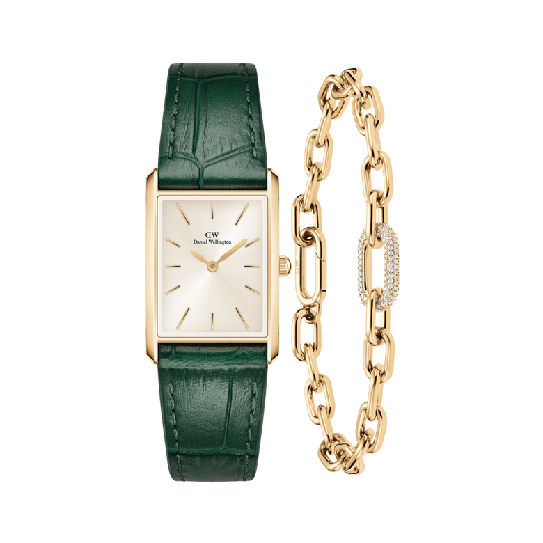 Rectangular gold-framed watch with a champagne sunray dial and deep green crocodile-embossed leather strap, paired with a gold crystal link bracelet featuring an adjustable chain and sparkling crystal detail.