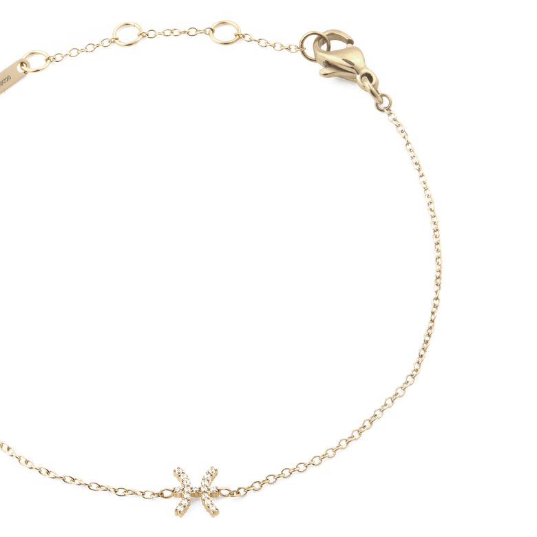 Close-up of the Crystal Zodiac Chain Bracelet Gold, highlighting the slim gold chain, adjustable sizing rings, and a sparkling Pisces zodiac charm set with crystals.