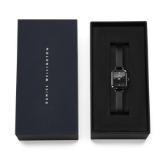 Quadro Mini Reflection Black watch with a rectangular black dial and slim mesh strap, presented in a Daniel Wellington gift box, ideal for gifting or adding to your collection.